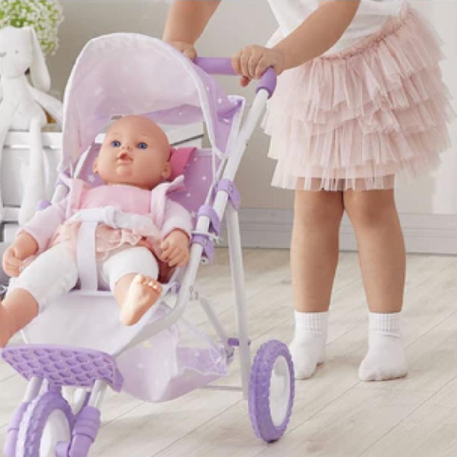 A little girl in a pink tutu is pushing a baby doll in a purple stroller