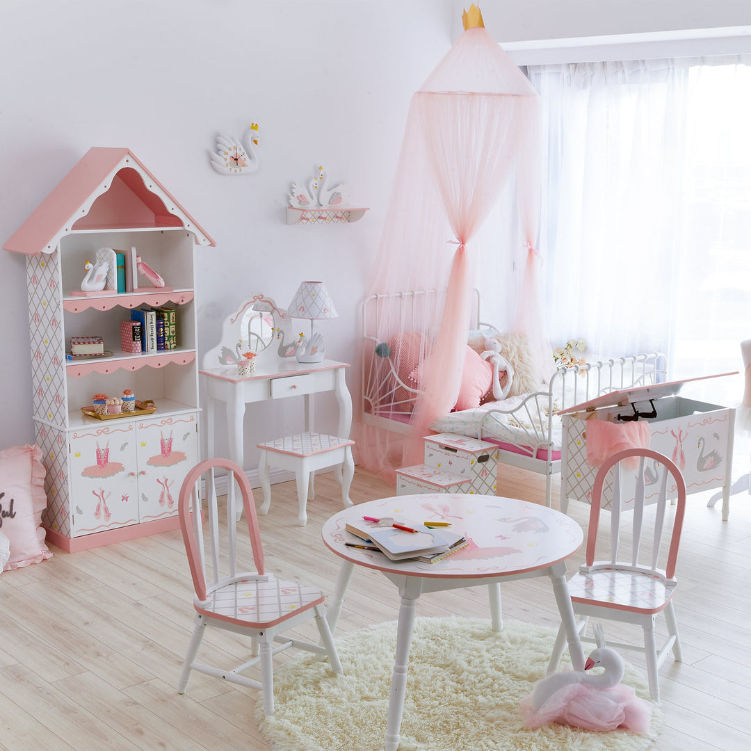 A whole room decorated in Teamson swan lake theme featuring a table and chairs, a bookcase, vanity and a storage chest.