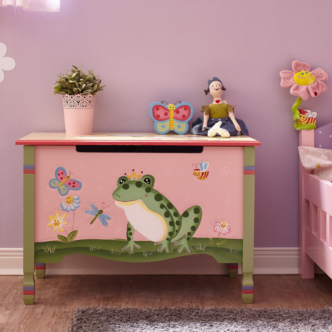 A whimsically painted toy chest sits in a girls bedroom