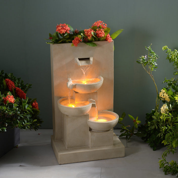 An illuminated 29.13" Outdoor Water Fountain with Planter & LED Lights, Natural in a dimly lit room.