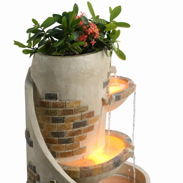 Close up image of the back side of the fountain with plants in the top portion.