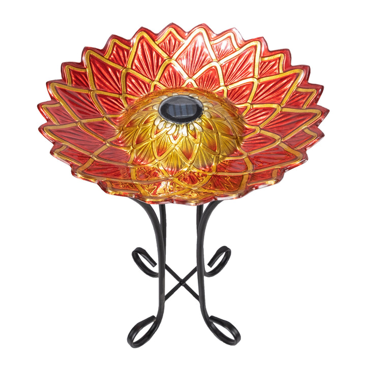 Decorative 17.8" Dahlia Fusion Glass Birdbath with Solar-Powered Light, Red perched on a metal stand.