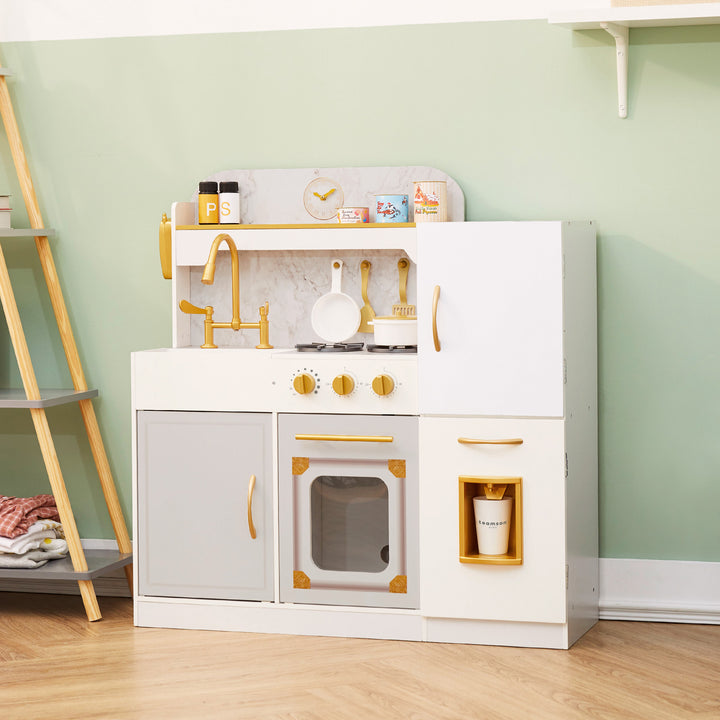 A white play kitchen with gold hardware with an sink, oven and refrigerator