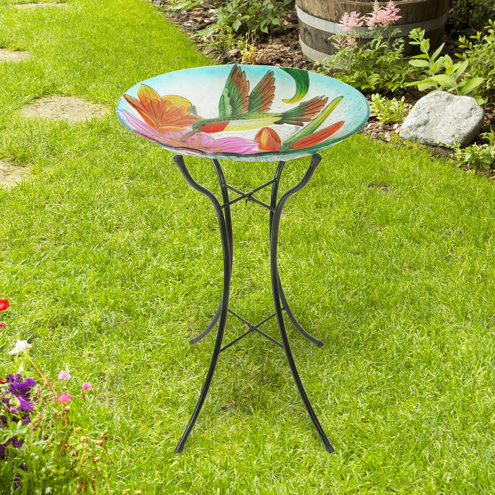 Birdbath features a hummingbird and lily flowers, standing in a garden