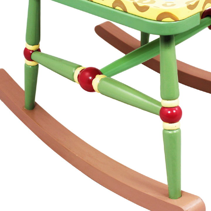 Close-up of the brown rockers and the green chair legs with red and yellow design.