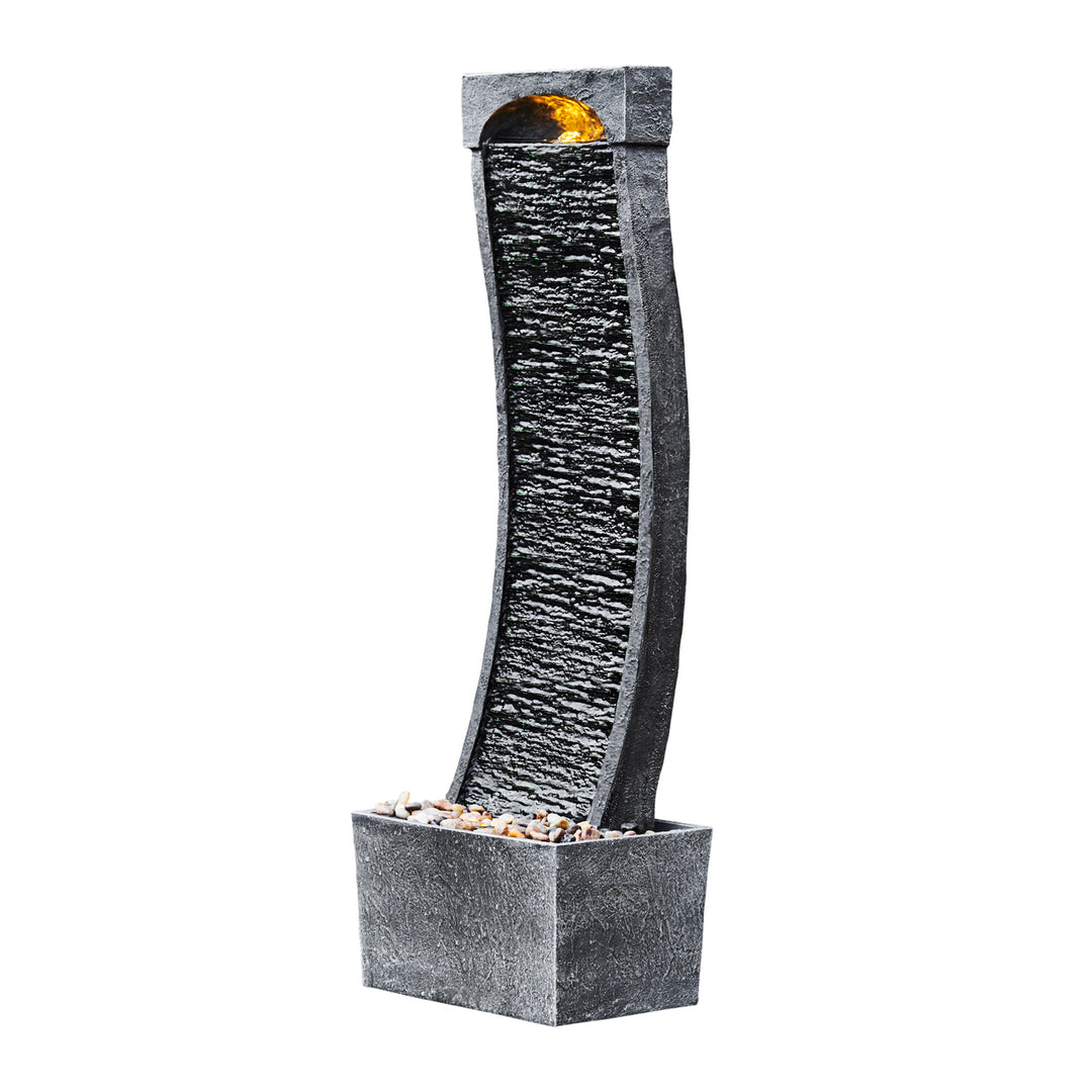 Sideview of a black wavy waterfall style water fountain and base with pebbles