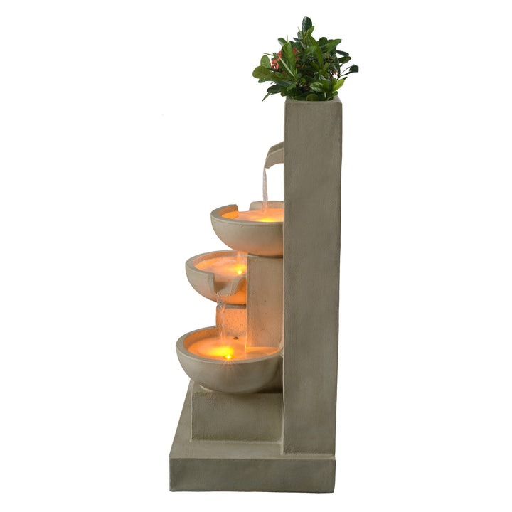 A view from the side with the planter on top and water cascading down tier to tier, each illuminated with LED lights