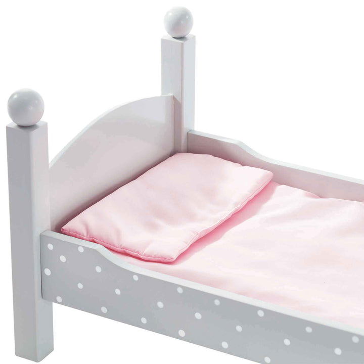 Close-up of the pink pillow and blanket on a gray with white polka dots bed.