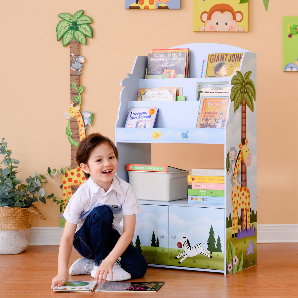 A boy is sitting on the floor reading a book from the Fantasy Fields Sunny Safari Kids 3-Tier Wooden Bookshelf with Storage, Multicolor about jungle creatures.