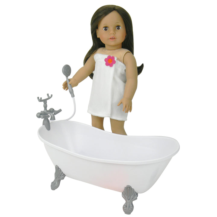 A brunette 18" doll in a white terry cloth wrap with a sprayer in her hand next to a white bathtub.