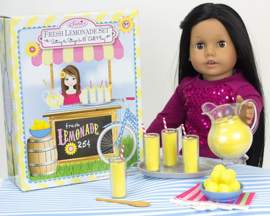 A black-haired 18" doll pouring lemonade into glasses filled with lemonade.