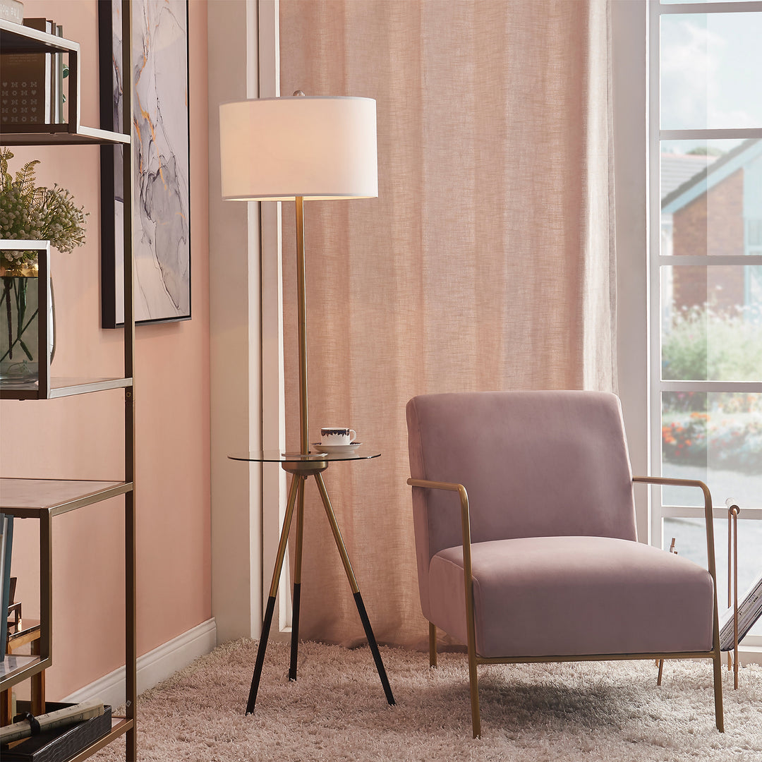 A Teamson Home Myra Floor Lamp with Table, Gold/White Shade sat next to a pink and gold accent chair near a window with a long, blush-colored sheer