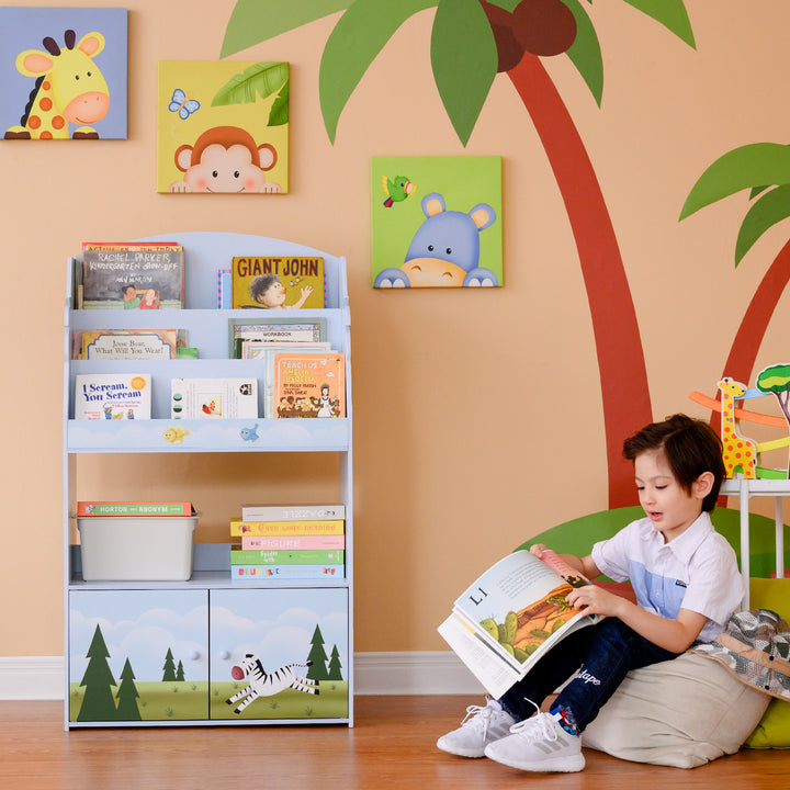 A boy is reading a Fantasy Fields Sunny Safari Kids 3-Tier Wooden Bookshelf with Storage, Multicolor about jungle creatures in a room.