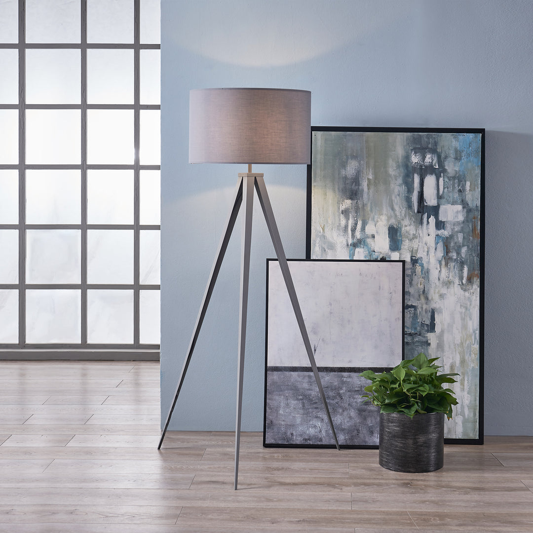 Teamson Home Romanza 62" Postmodern Tripod Floor Lamp with Drum Shade, Gray next to an abstract painting and a potted plant in a modern interior.