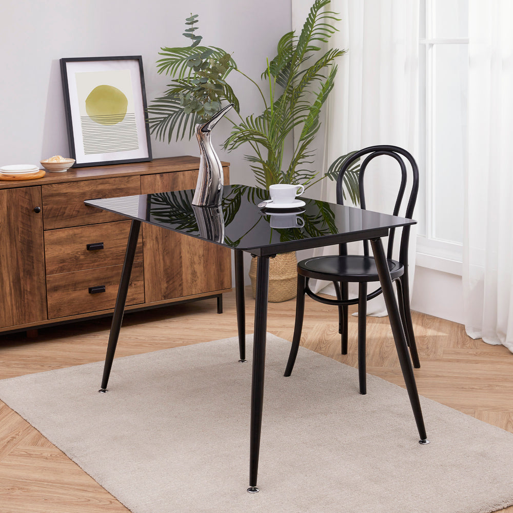 Teamson Home Julianna Reflective Glass Dining Table, Black, next to a sideboard in a dining room
