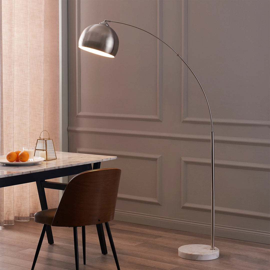 A contemporary dining room featuring a table, chair, and an arc floor lamp.
