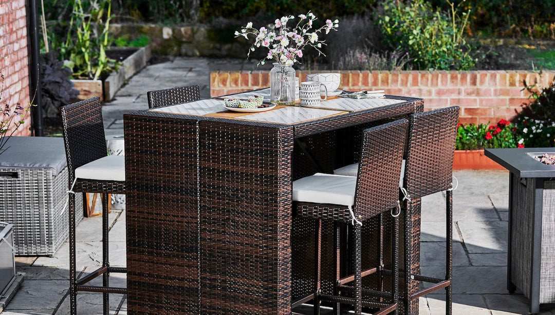 Outdoor bar height table with four stools. Brown PE rattan with cushions.