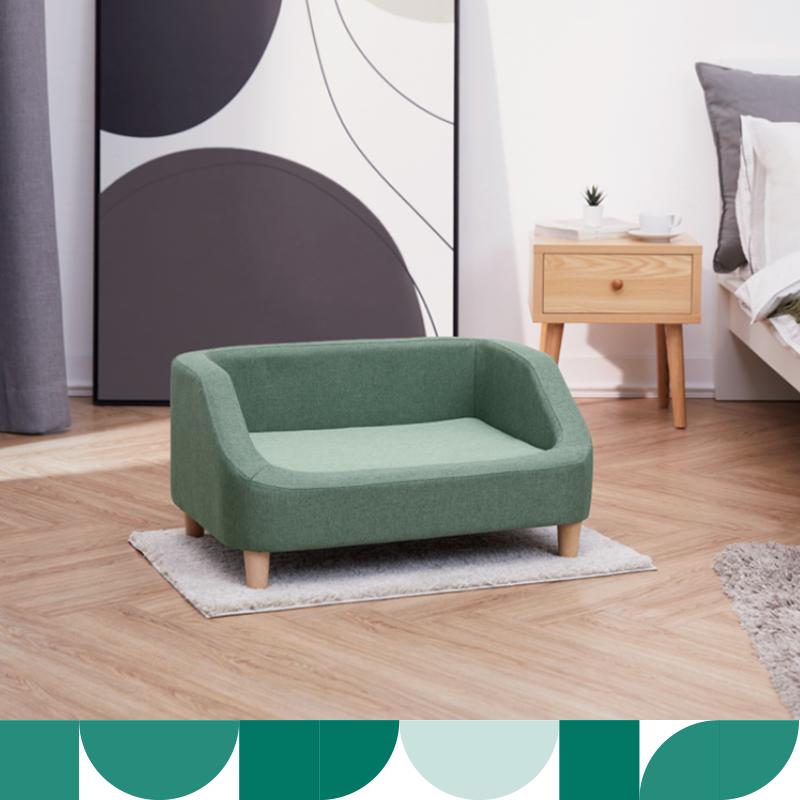 a luxurious green pet sized couch sits in a bedroom
