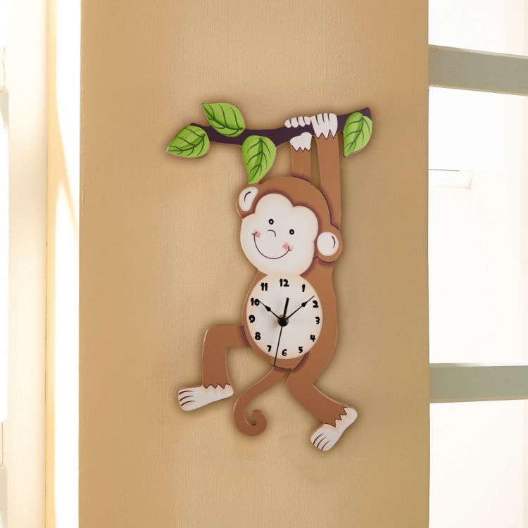 An animated monkey kids clock hangs on a tan wall.
