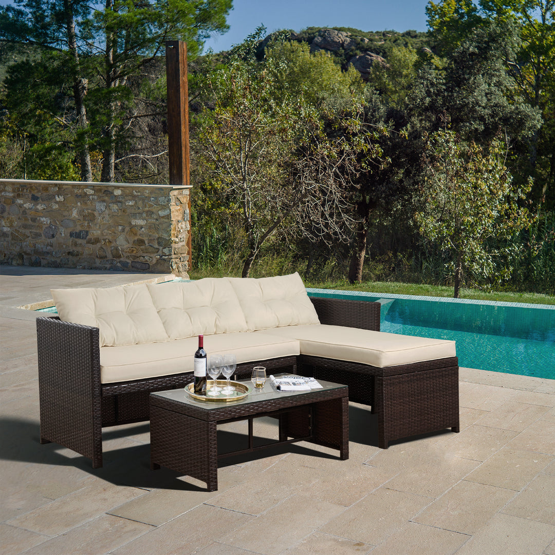 A set of patio furniture including table, chairs and cushions in a garden by a swimming pool.