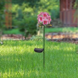 A beautiful pink flower garden decor is staked on a vibrant green lawn.