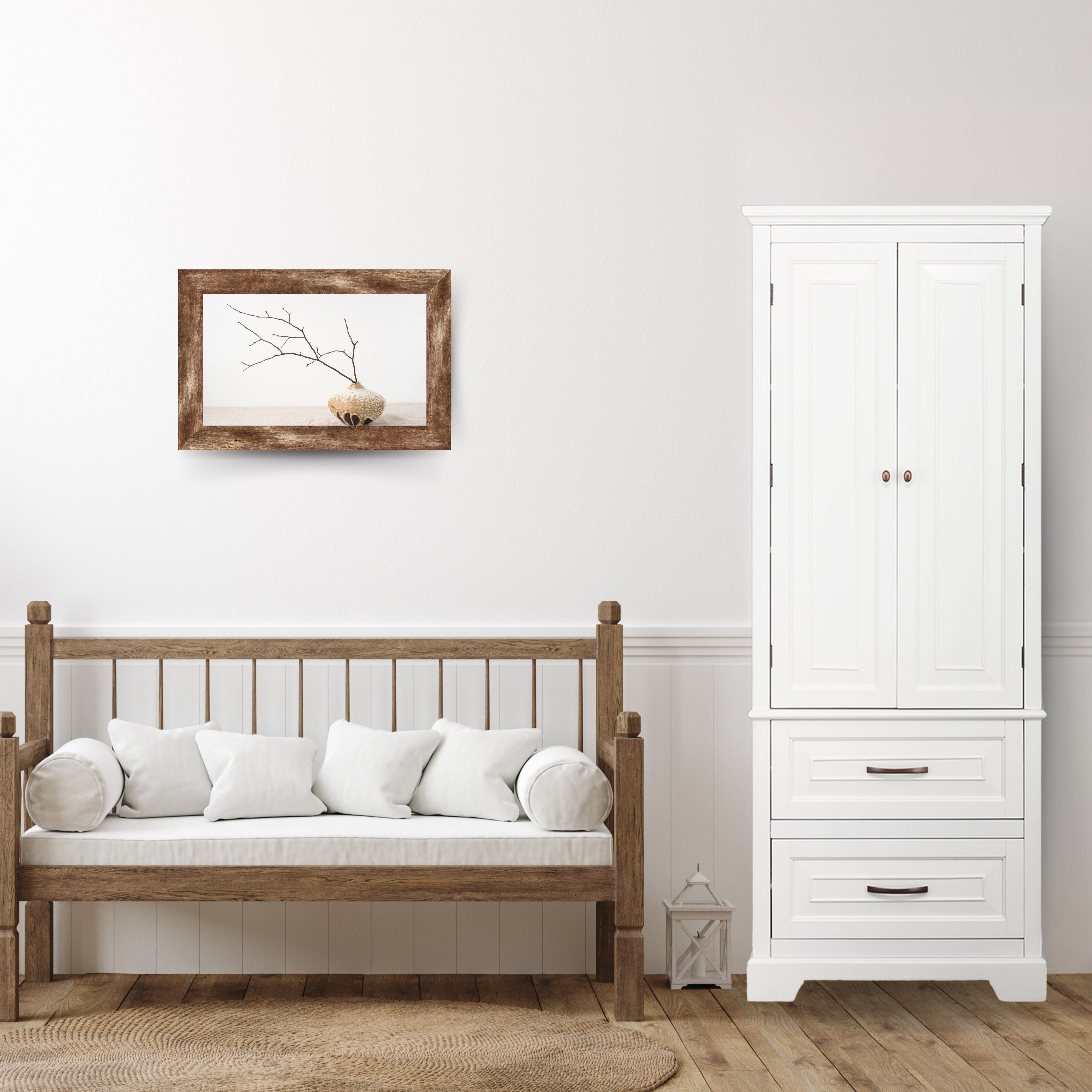 A wooden bench with white cushions against a white wall, next to a white double-door cabinet with two lower drawers.