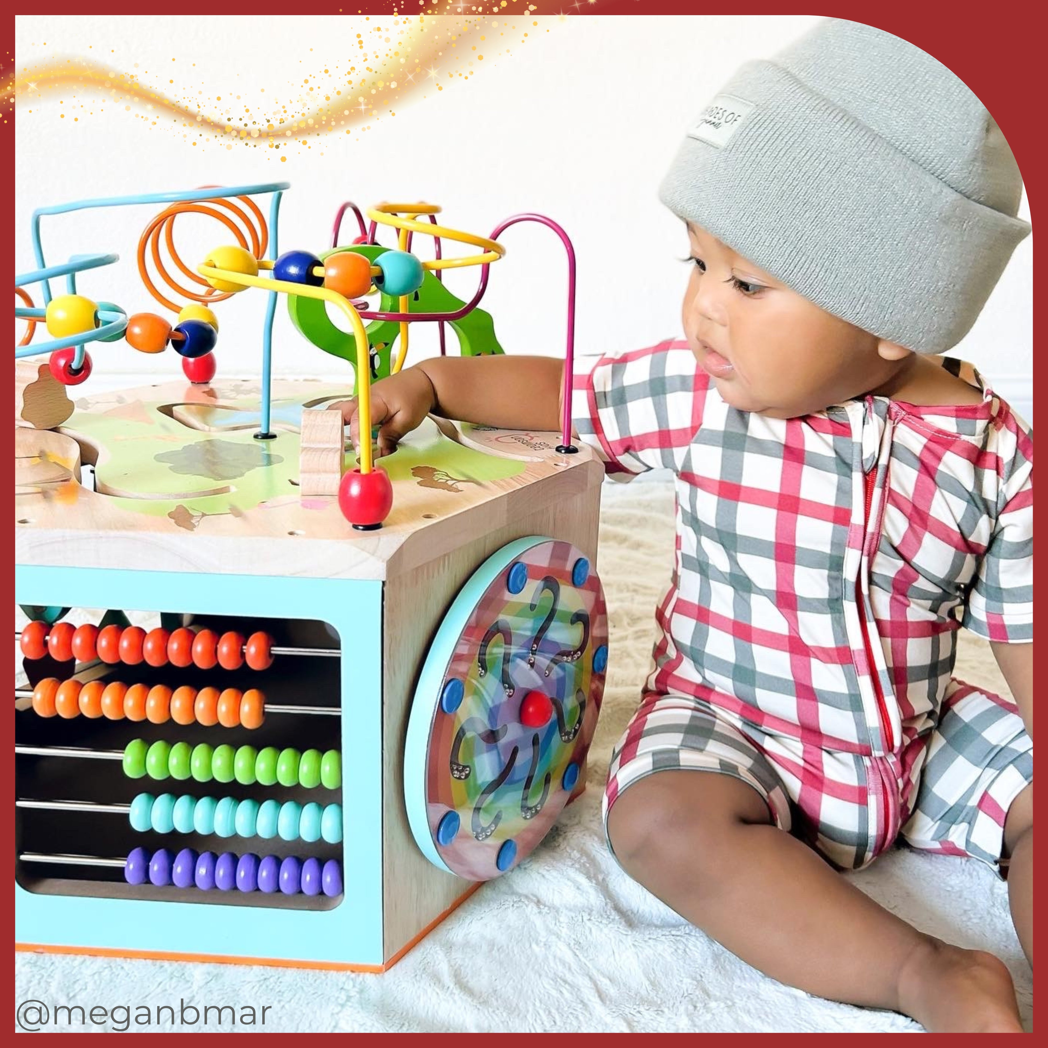 a baby boy plays intently at his busy wooden activity set