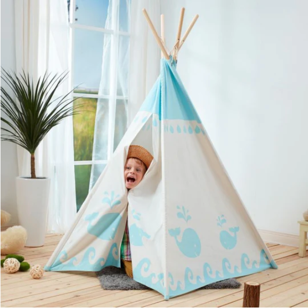 Child peeking head out of a teepee in a living room.