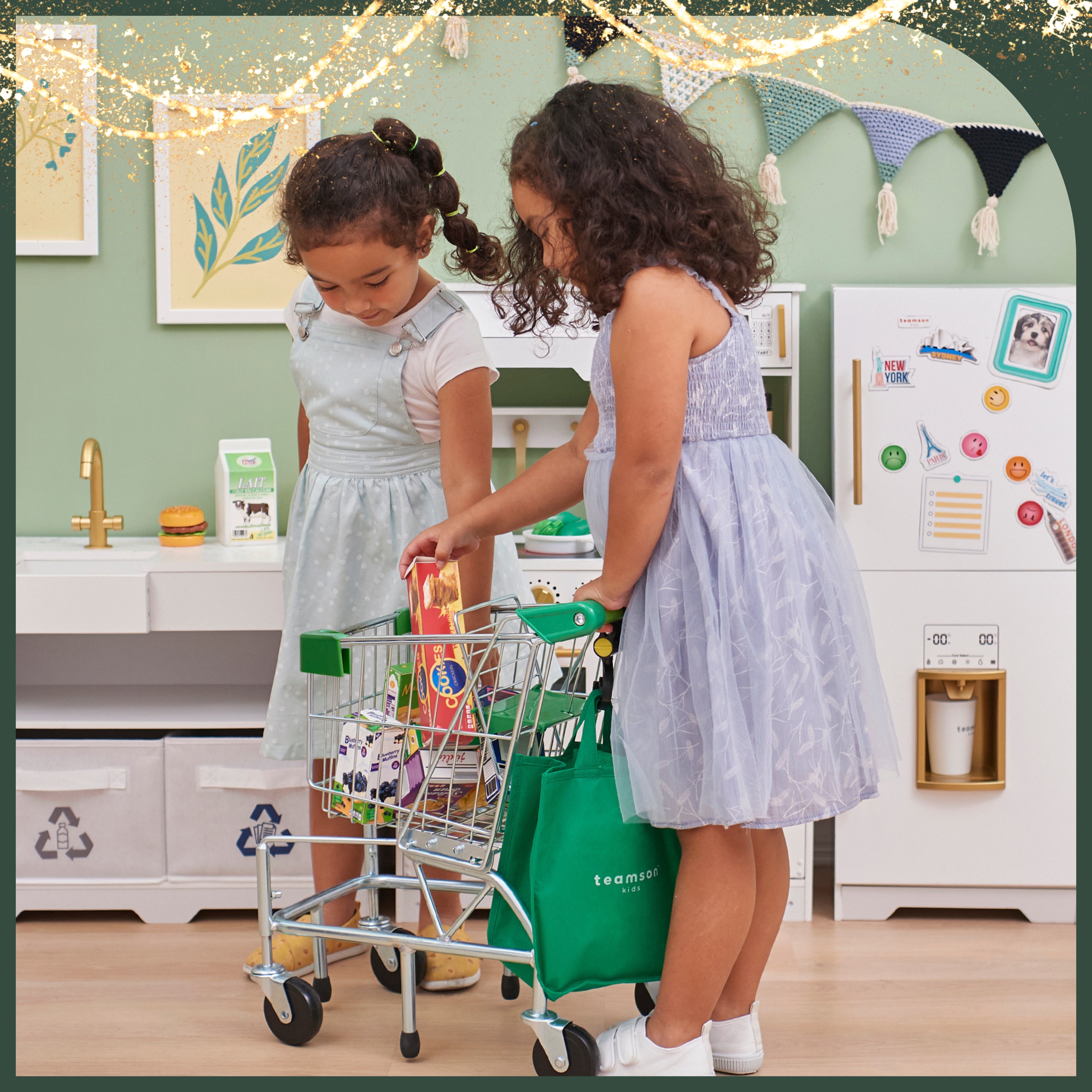 two girls fill their grocery cart with pretend food