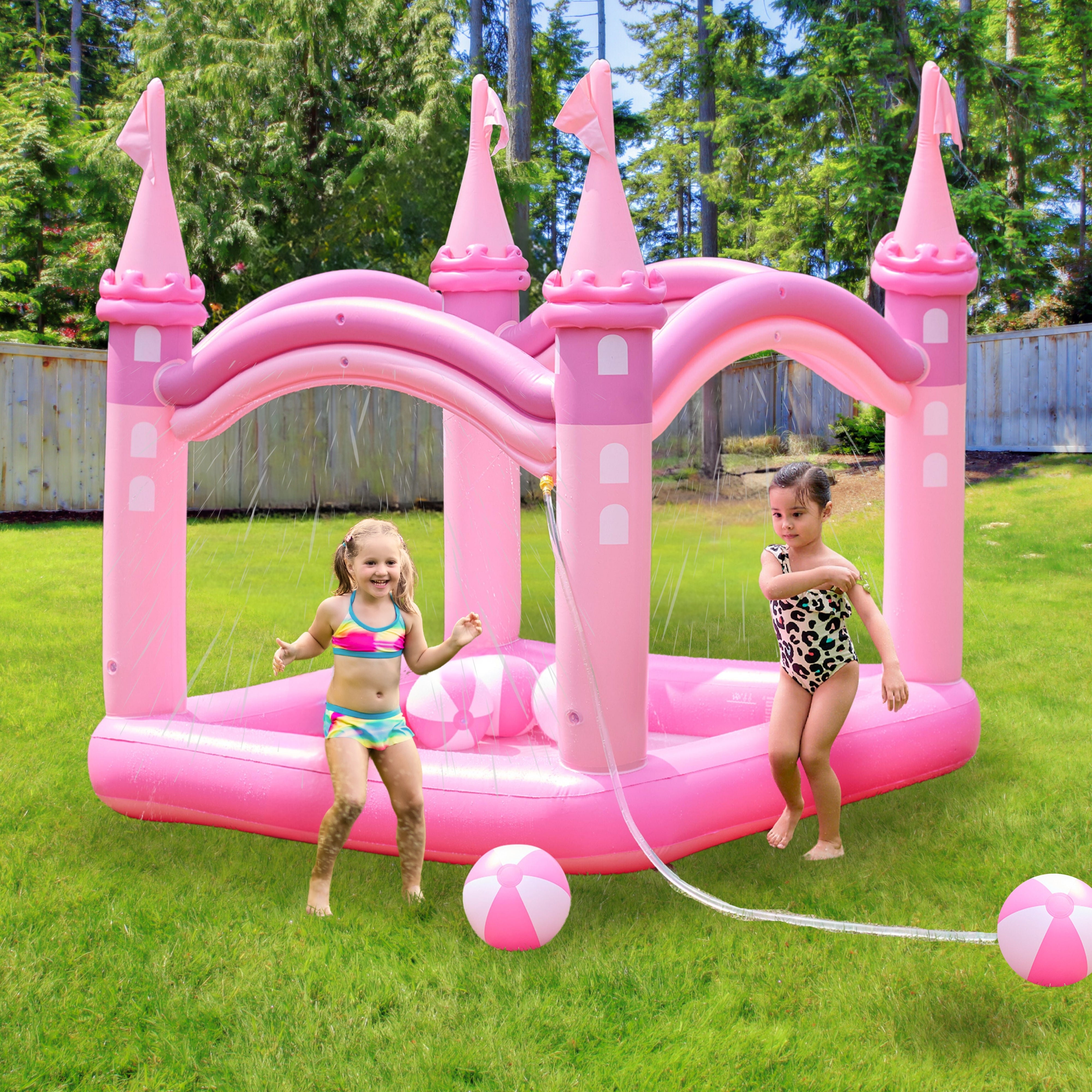 2 kids playing in a pink Inflatable kiddie pool with beach balls in a backyard.