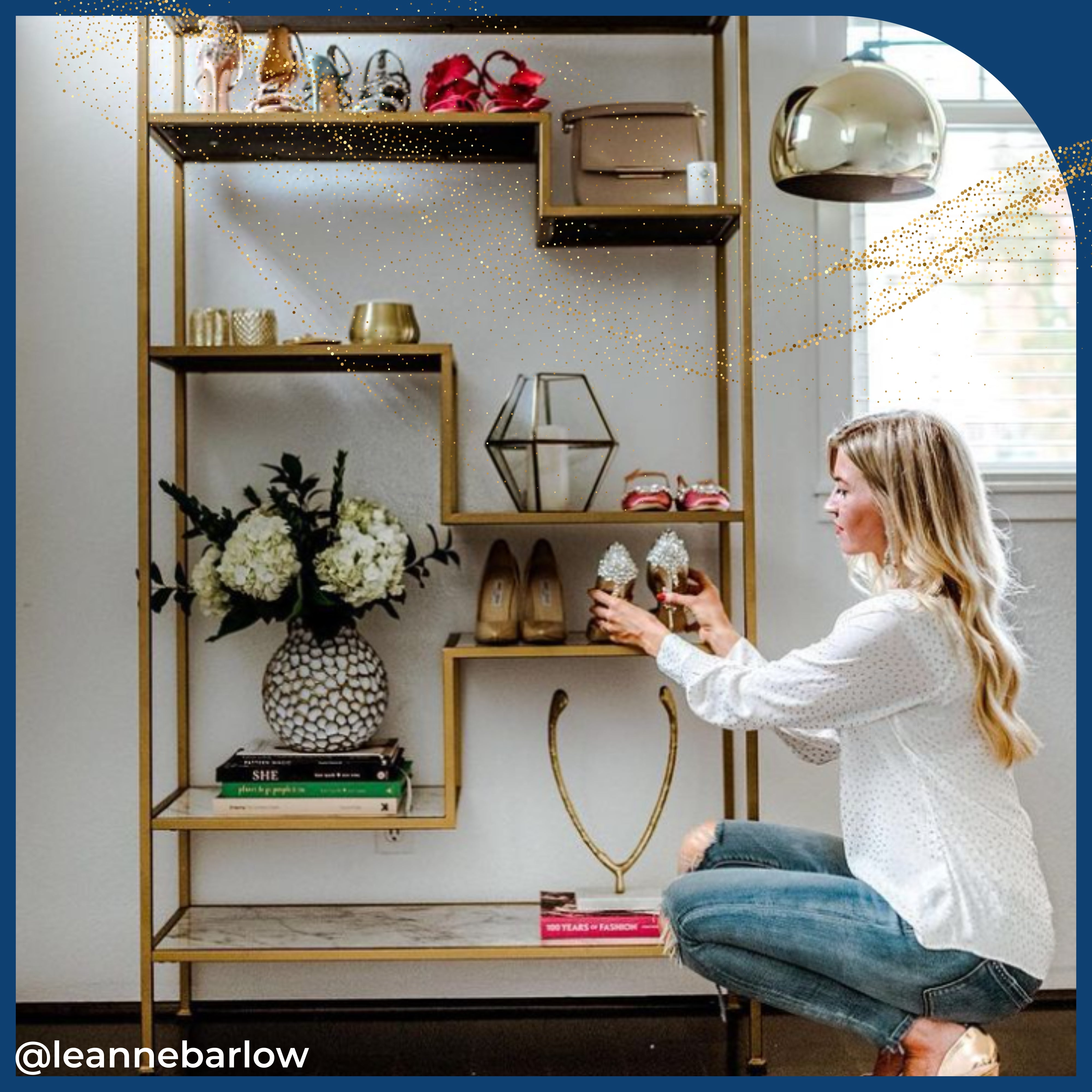 the gold and faux marble shelving unit displays books, vases and more