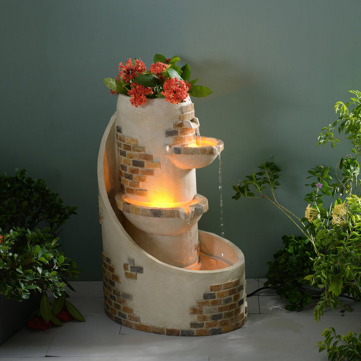 29.92" Outdoor Water Fountain with Planter, Ivory with cascading bowls, adorned with red flowers in a twilight setting, highlighting the LED lights