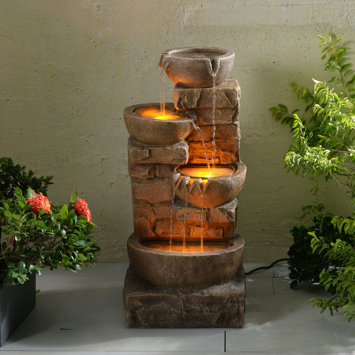 33.27" Cascading Bowls & Stacked Stones LED Outdoor Fountain, Brown with flowing water and illuminated bowls, set in a garden ambiance.