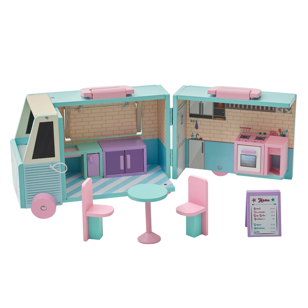 The pink and blue doll food truck opened with the sink and cooler on the left side of the truck and the stove and counter on the right side of the truck. The table and two chairs are set up away from the truck with the sandwich board.