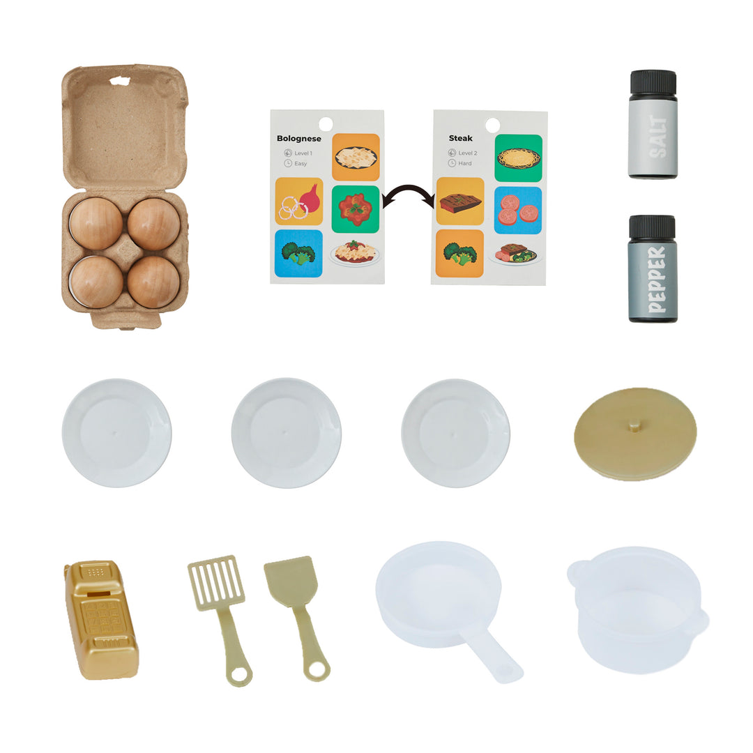 Flat lay of Teamson Kids - Little Chef Memphis Small Play Kitchen, Gray/Gold items and play food including eggs, packaging, utensils, and dishes.