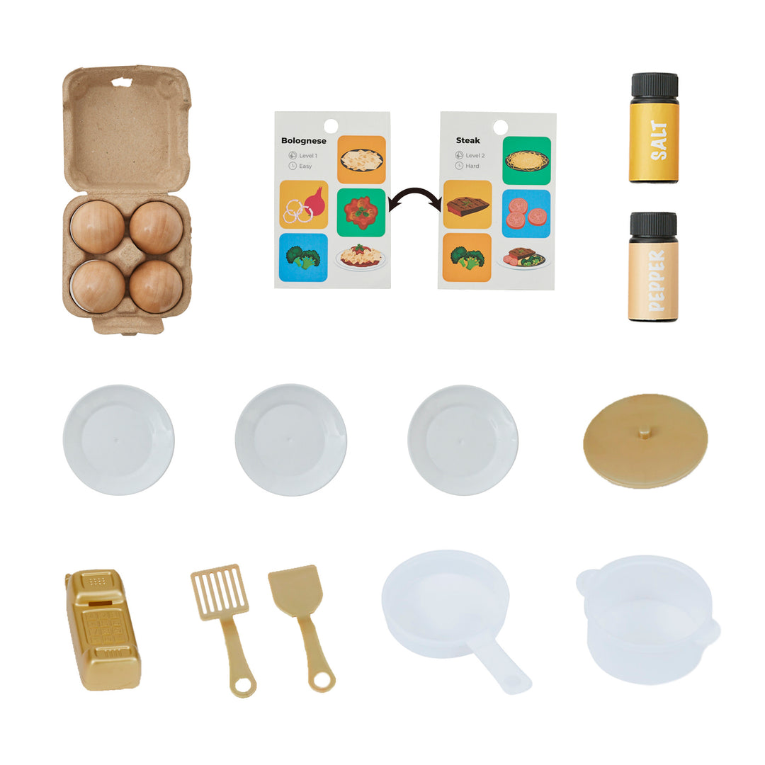 A set of accessories includes four eggs in a carton, a reversible recipe card, salt and pepper shakers, three white plates, a gold lid that fits a white pan or pot, two spatulas and a pretend wireless phone.