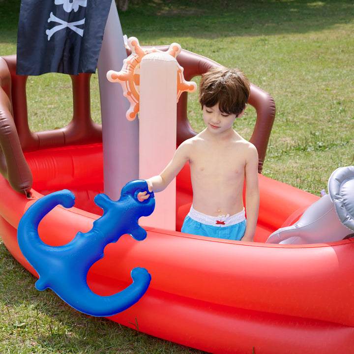 Young boy playing with a Teamson Kids - Water Fun Pirate boat Inflatable Sprinkler Play in an inflatable pirate ship pool.