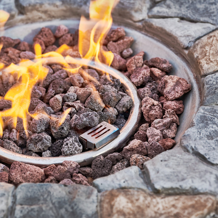 A Teamson Home 28" Outdoor Round Stone Propane Gas Fire Pit with lava rocks and visible flames, perfect for outdoor décor.
