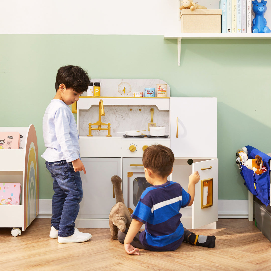 Two little boys and a stuffed dinosaur playing with a kids play kitchen