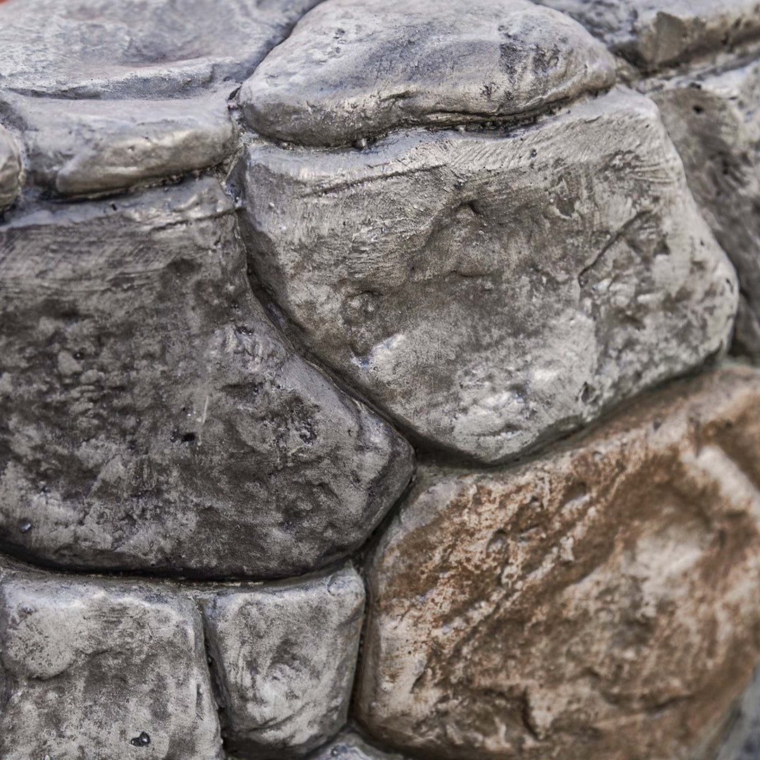 Close-up of a textured Teamson Home 28" Outdoor Round Stone Propane Gas Fire Pit, Stone Gray, with the realistic texture of the rock