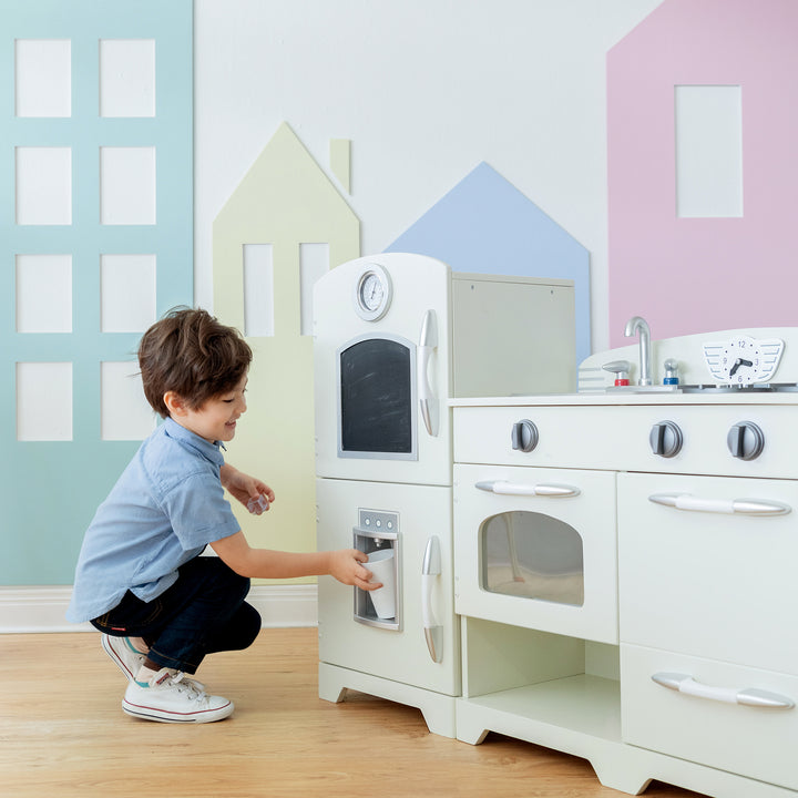 A young child plays with an easy-to-clean Teamson Kids Little Chef Fairfield Retro Kids Kitchen Playset with Refrigerator, Ivory in a colorful room.