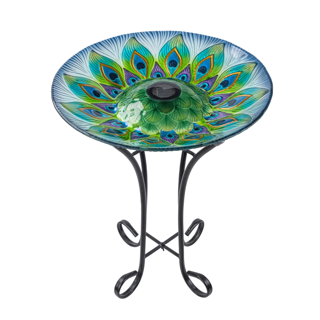 A 17.8" Peacock Fusion Glass Birdbath with Solar-Powered Light, Blue and Green, on a metal stand.