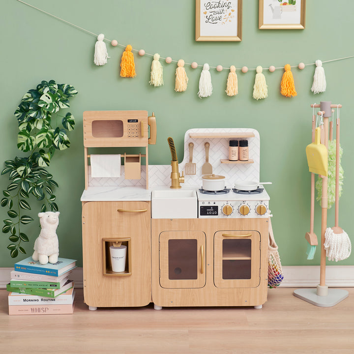 Child's Teamson Kids - Little Chef Cyprus Medium Play Kitchen, Light Oak/White set with accessories in a room with green walls and decorative elements.