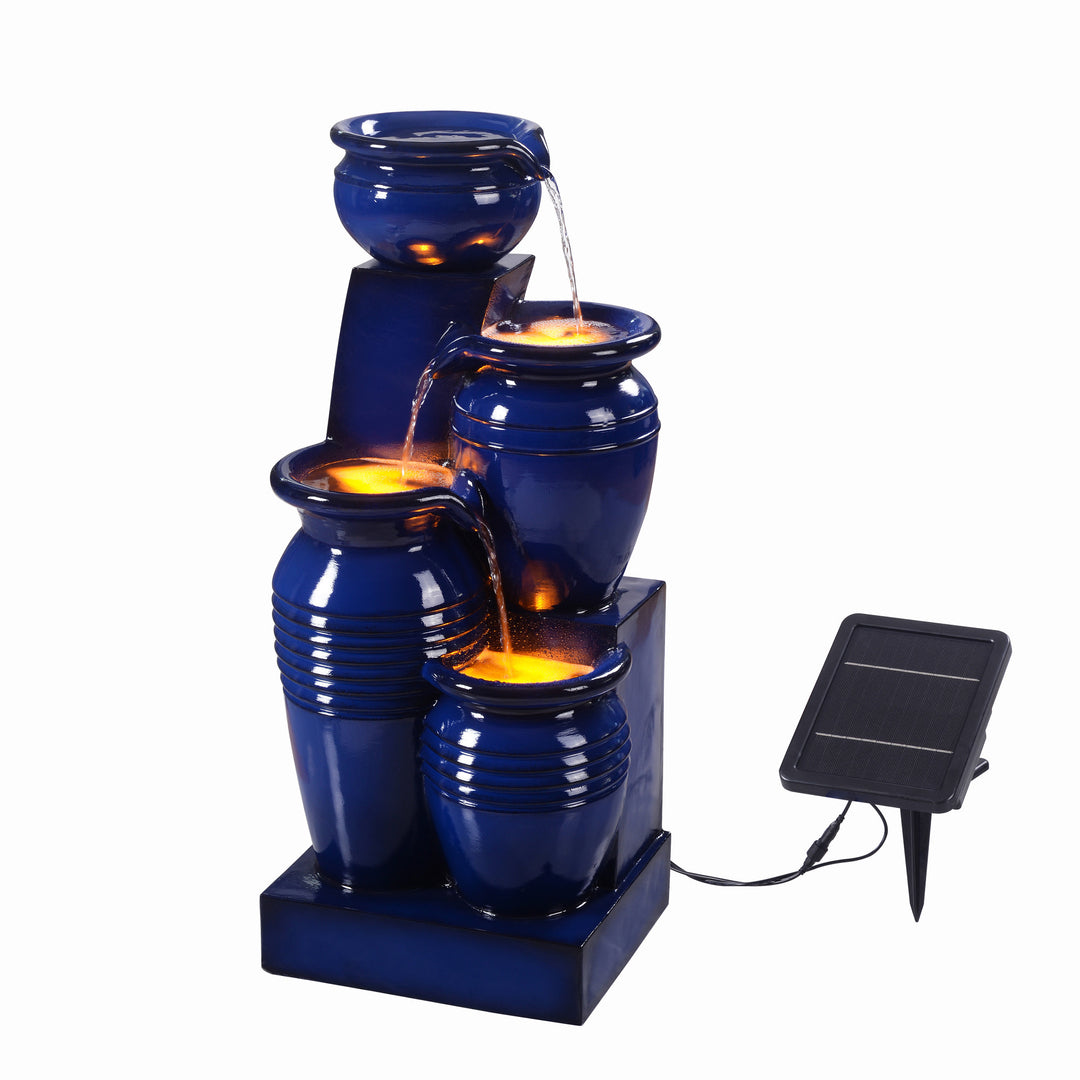 Teamson Home 28.74" Navy Blue 4-Tier Outdoor Solar Water Fountain with LED Lights illuminated underneath the flowing water, connected to a solar panel