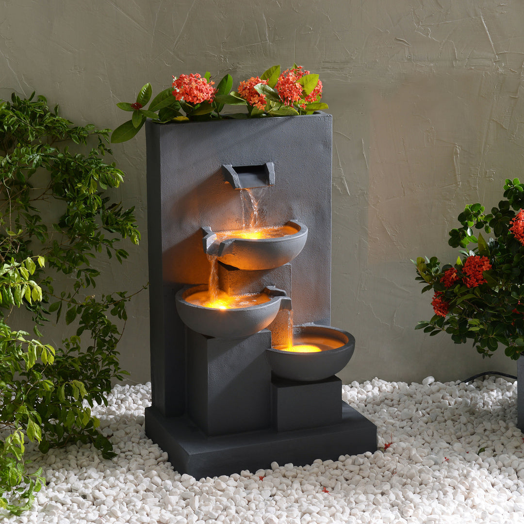 Outdoor Water Fountain with Planter in a matte gray with flowers in the planter feature at the top