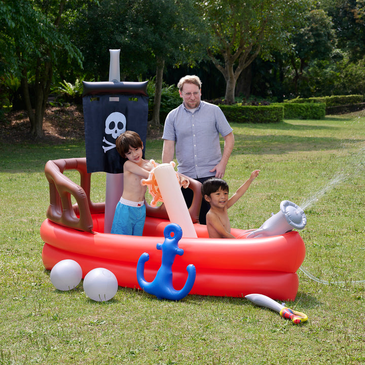 Family enjoying a Teamson Kids - Water Fun Pirate boat Inflatable Sprinkler Play with water shooters on a sunny day.