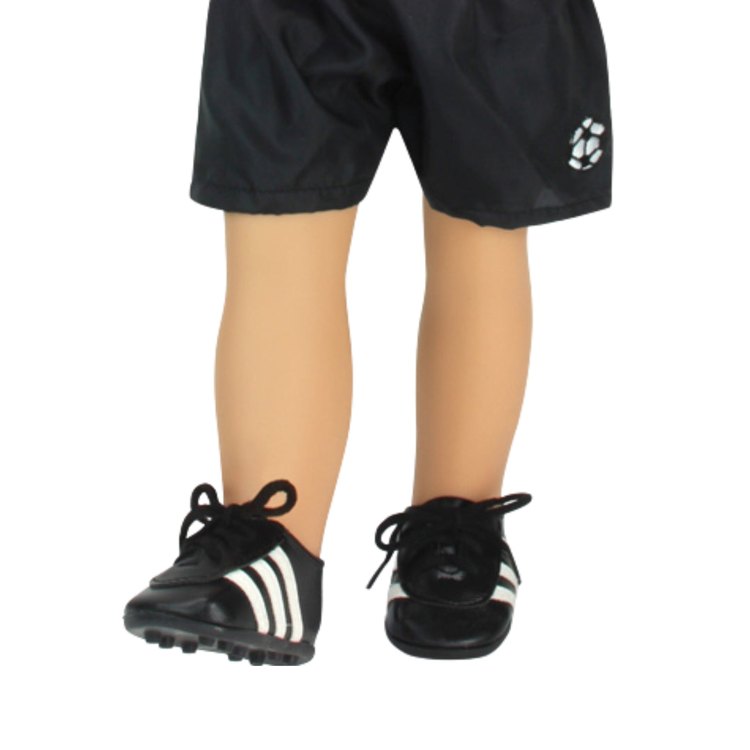 A close-up of a pair of black soccer shorts and cleats on an 18" doll.