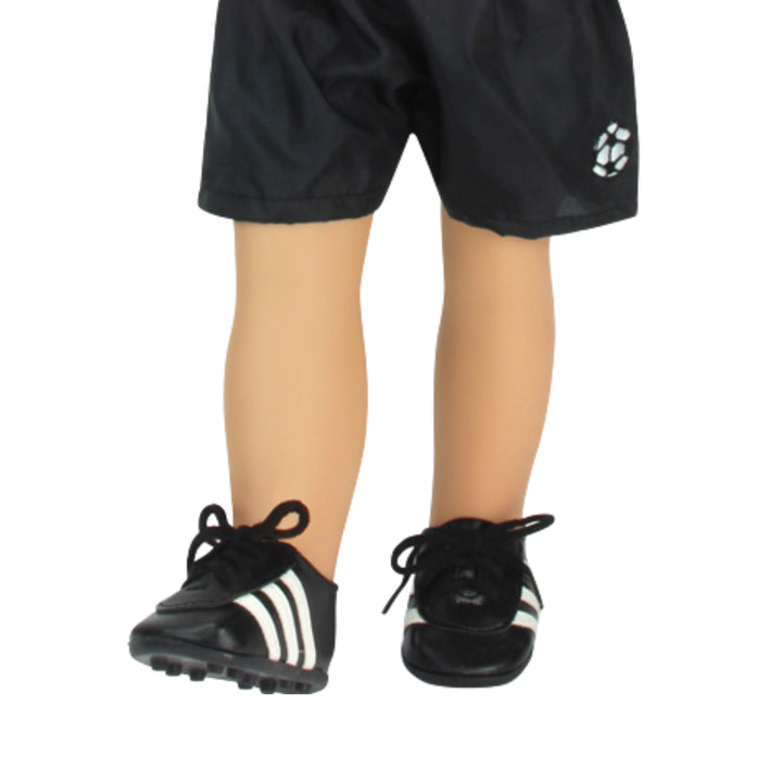 A close-up of a pair of black soccer shorts and cleats on an 18" doll.