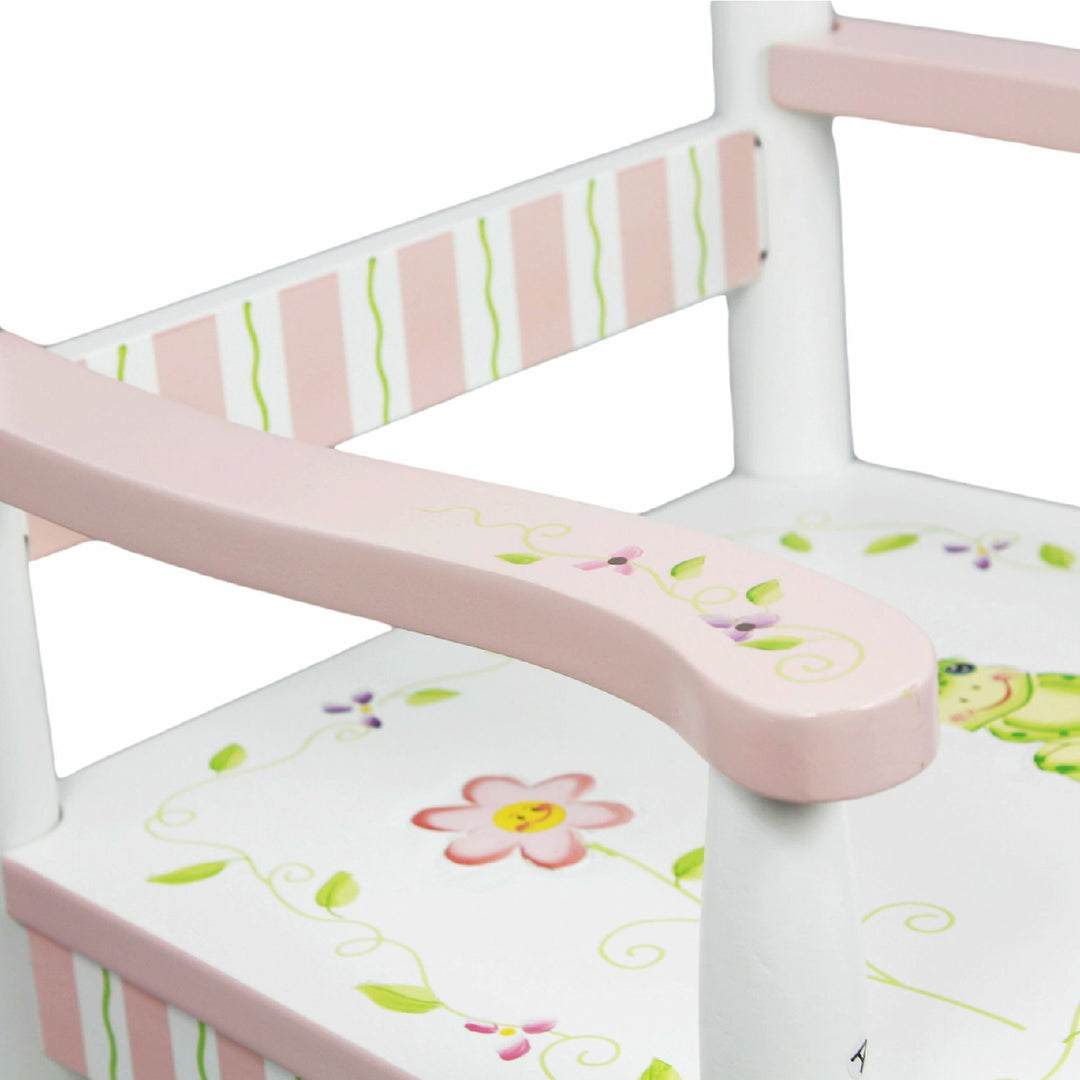 A white and pink rocking chair with a close up of the seat with a frog and floral accents.
