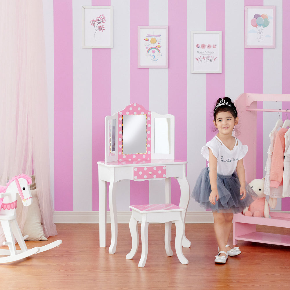 A little girl's bedroom with a pink Fantasy Fields Gisele Polka Dot Prints Play Vanity Set with LED Mirror Light.